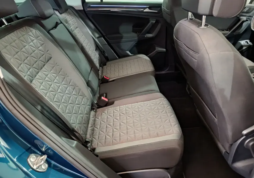 Vue intérieure côté gauche sur la banquette arrière grise au tissu matelassé du Volkswagen Tiguan bleu 2022 hybride rechargeable.