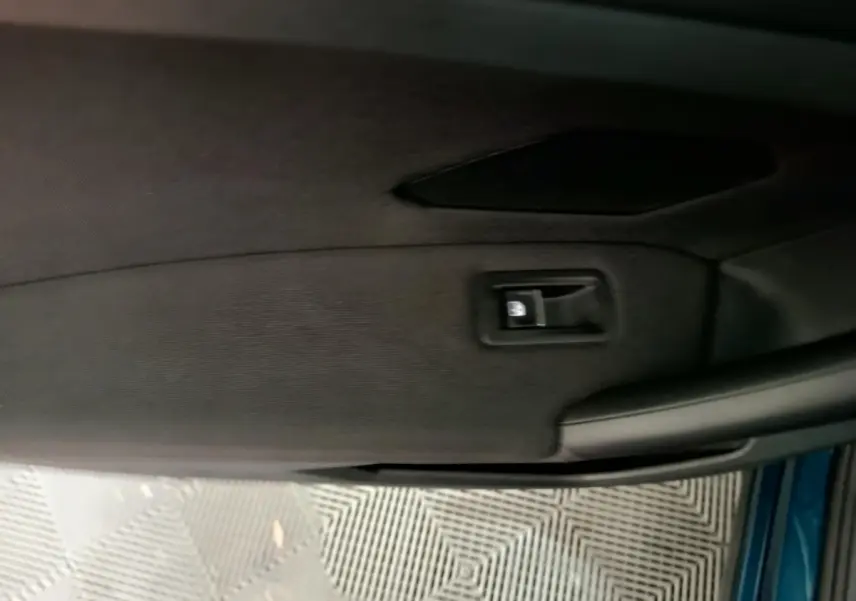 Détail de la poignée intérieure côté gauche d'une Volkswagen Tiguan hybride rechargeable bleu 2022.