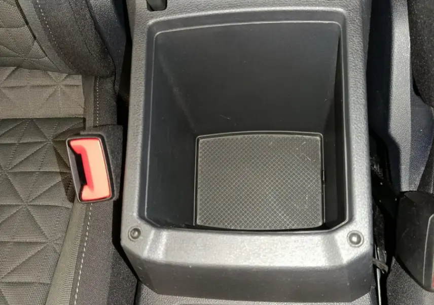 Vue plongeante sur le rangement central noir et porte-gobelets du Volkswagen Tiguan bleu hybride rechargeable 2022.