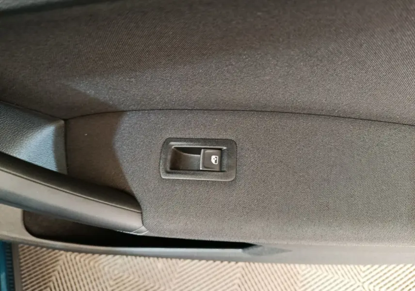 Bouton de verrouillage de porte sur la garniture intérieure noire de la porte côté gauche du Volkswagen Tiguan bleu hybride.