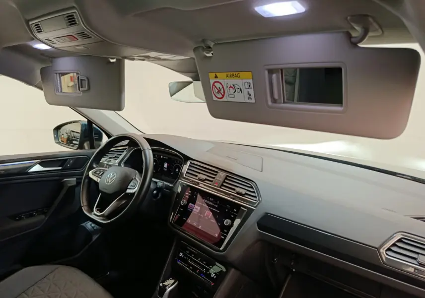 Vue intérieure côté conducteur du Volkswagen Tiguan 2022, tableau de bord et écran tactile visibles.