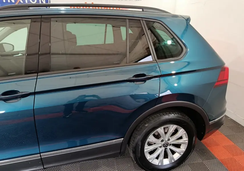 Vue côté droit arrière du Volkswagen Tiguan bleu 2022, mettant en valeur la jante alliage et la ligne de caisse.
