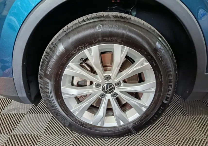 Gros plan sur la roue avant droite d’un Volkswagen Tiguan bleu 2022 avec jante alliage et pneu Michelin.