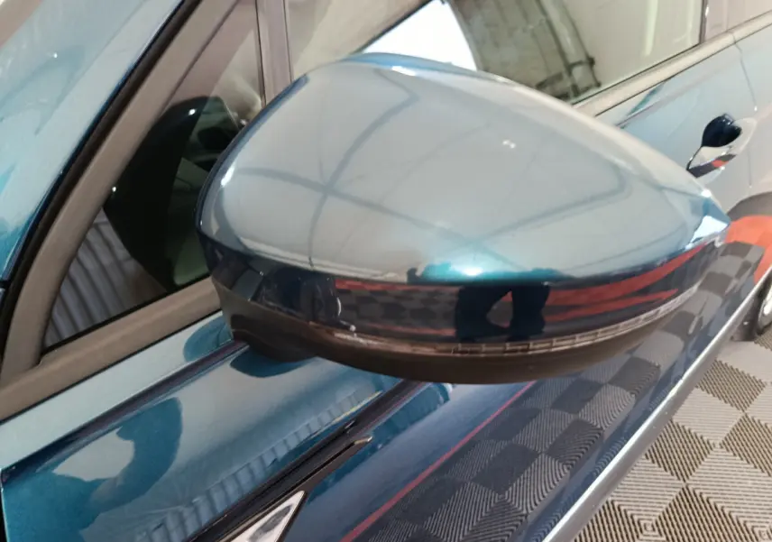 Rétroviseur côté gauche bleu métallisé du Volkswagen Tiguan 1.4 eHybrid 2022 avec clignotant intégré.