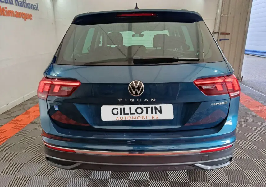 Vue arrière d'un Volkswagen Tiguan bleu hybride rechargeable 2022 avec logo et feux LED distinctifs.