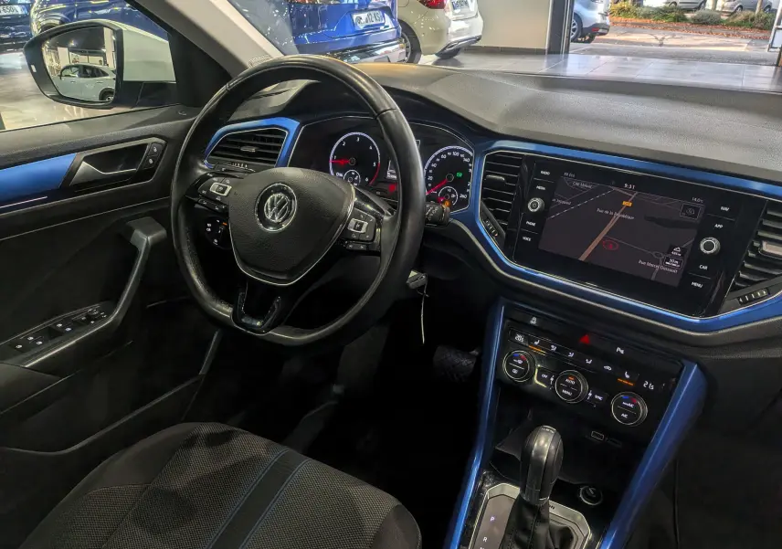 Intérieur du Volkswagen T-Roc 2018 vu côté conducteur, tableau de bord et console centrale avec finition bleu Ravenna.