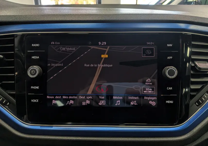 Écran tactile central du Volkswagen T-Roc 2018 avec navigation, entouré d'un cadre bleu Ravenna et commandes noires.