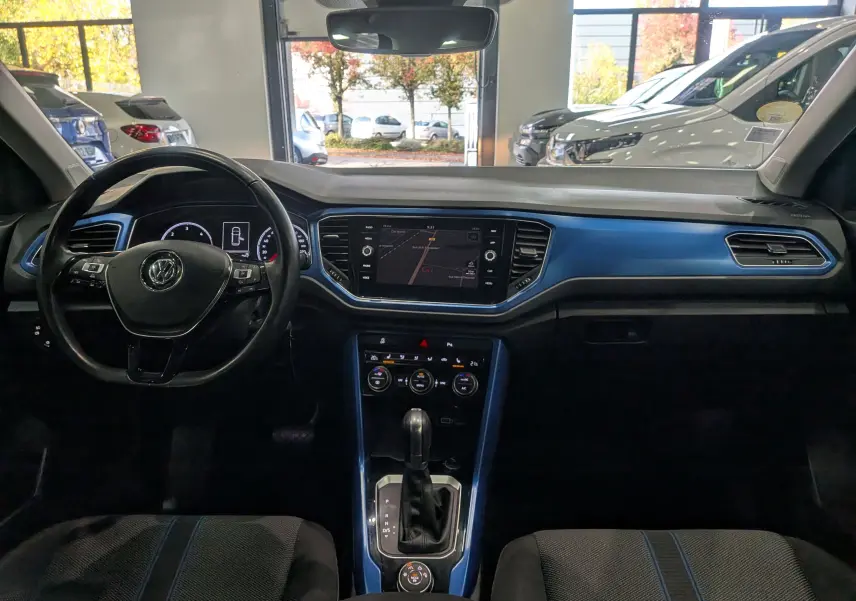 Intérieur du Volkswagen T-Roc 2018 avec tableau de bord bleu Ravenna, volant multifonction et écran central tactile.