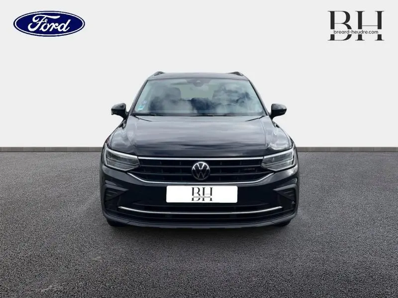 Vue frontale d'un Volkswagen Tiguan noir intense nacré, mettant en valeur sa calandre et ses phares LED.