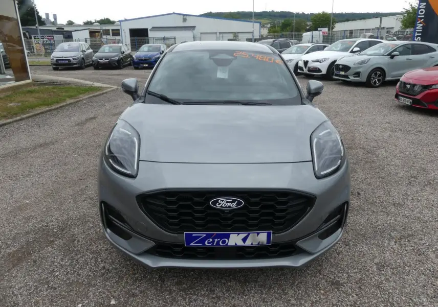 Vue frontale d'une Ford Puma gris métallisé avec calandre noire et phares LED, stationnée en extérieur.