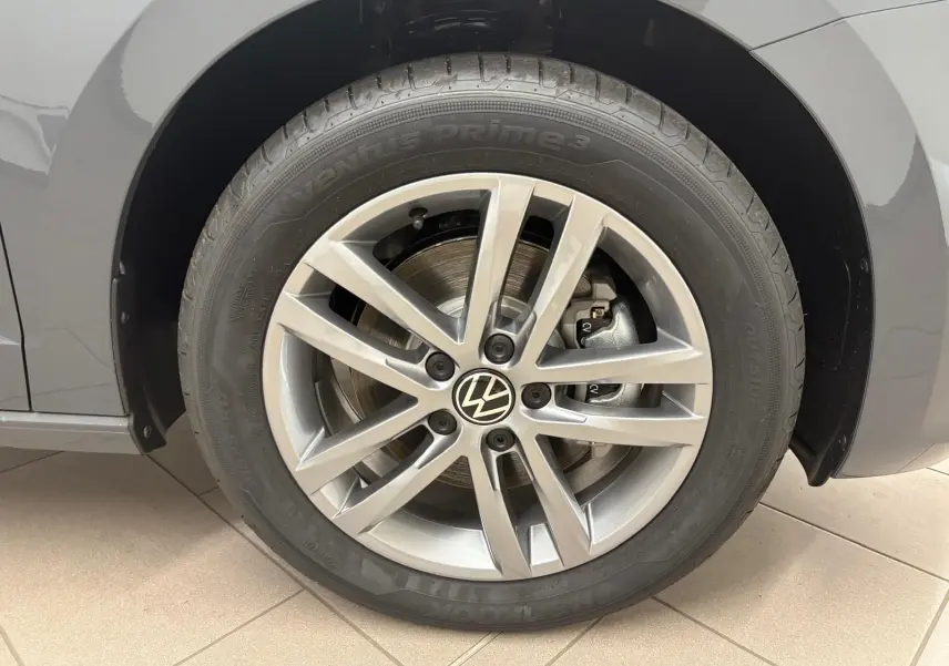 Gros plan sur la roue avant gauche gris dauphin du Volkswagen Touran 2025 avec jante alliage 17 pouces et logo VW central.