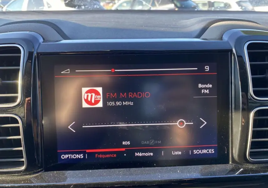 Écran tactile central du tableau de bord du Citroën C5 Aircross blanc, affichant la radio FM sur 105,90 MHz.