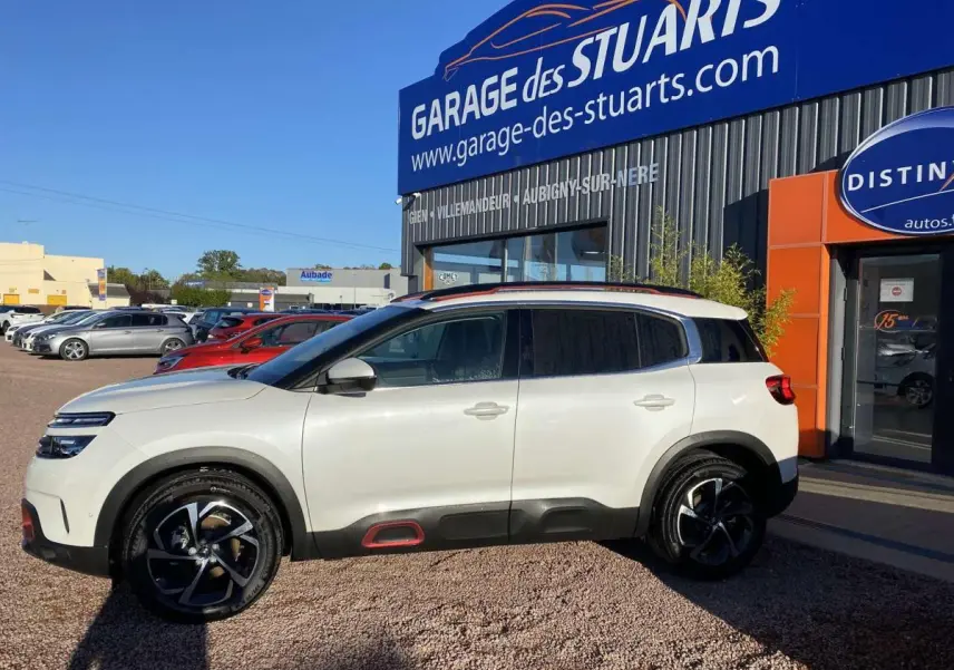 Vue de profil côté gauche d'un Citroën C5 Aircross blanc nacré avec inserts Deep Red et jantes bi-ton 18 pouces.