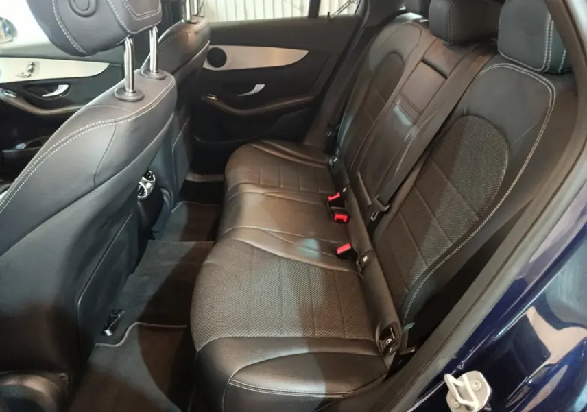 Vue côté droit de l'intérieur arrière du Mercedes GLC 300 E Business Line bleu, avec sièges en cuir noir et surpiqûres blanches.