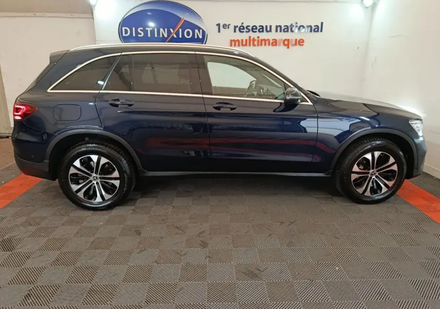 Profil côté droit d'un Mercedes GLC 300 E Business Line bleu hybride rechargeable, roues alliage et toit chromé visible.