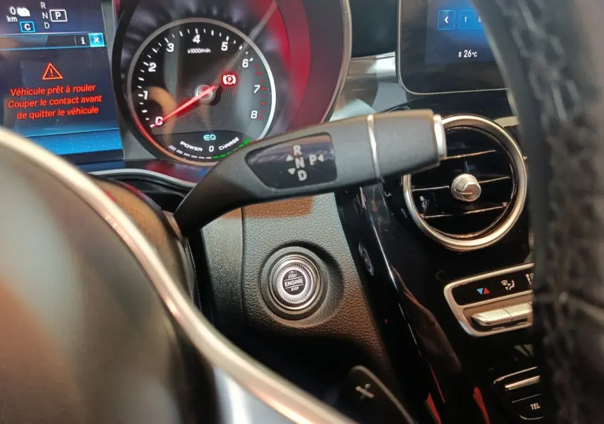 Gros plan intérieur sur le tableau de bord noir du Mercedes GLC 300 E hybride avec bouton démarrage et levier de vitesses.