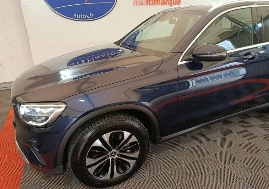 Vue de profil avant gauche d'un Mercedes GLC 300 E Business Line bleu avec jante alliage et feux LED visibles.