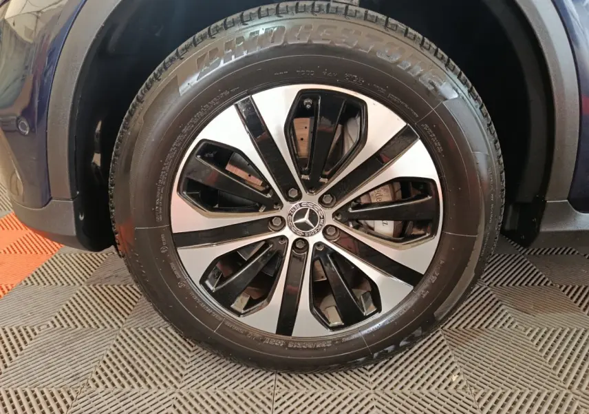 Gros plan sur la roue avant droite bleu Mercedes GLC 300 E avec jante alliage bicolore et pneu Bridgestone.