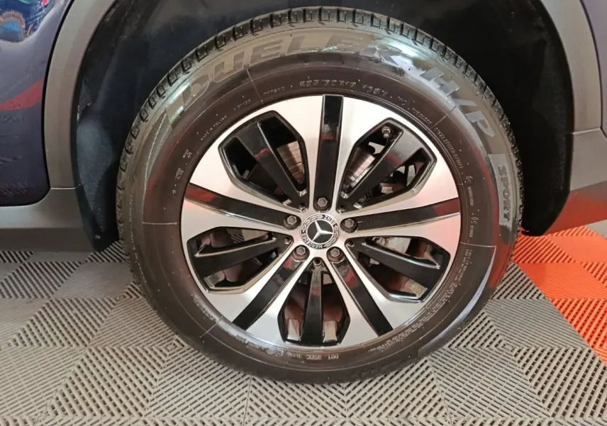 Gros plan sur la roue arrière droite d'un Mercedes GLC 300 E Business Line bleu, avec pneu sport visible.
