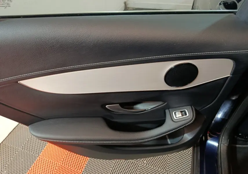 Gros plan sur la porte côté gauche du Mercedes GLC bleu 2021, avec garniture noire et insert aluminium brossé.