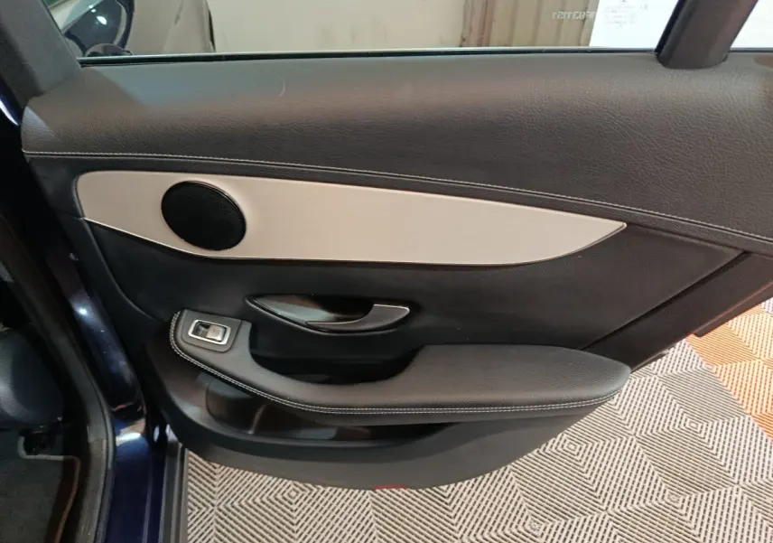 Gros plan sur la porte arrière gauche bleu foncé du Mercedes GLC 300 E avec garniture noire et insert aluminium.
