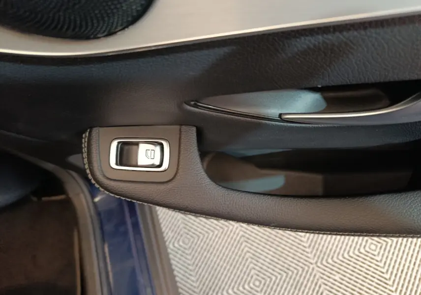 Détail de la commande de lève-vitre sur la porte côté conducteur d'un Mercedes GLC 300 E Business Line bleu.