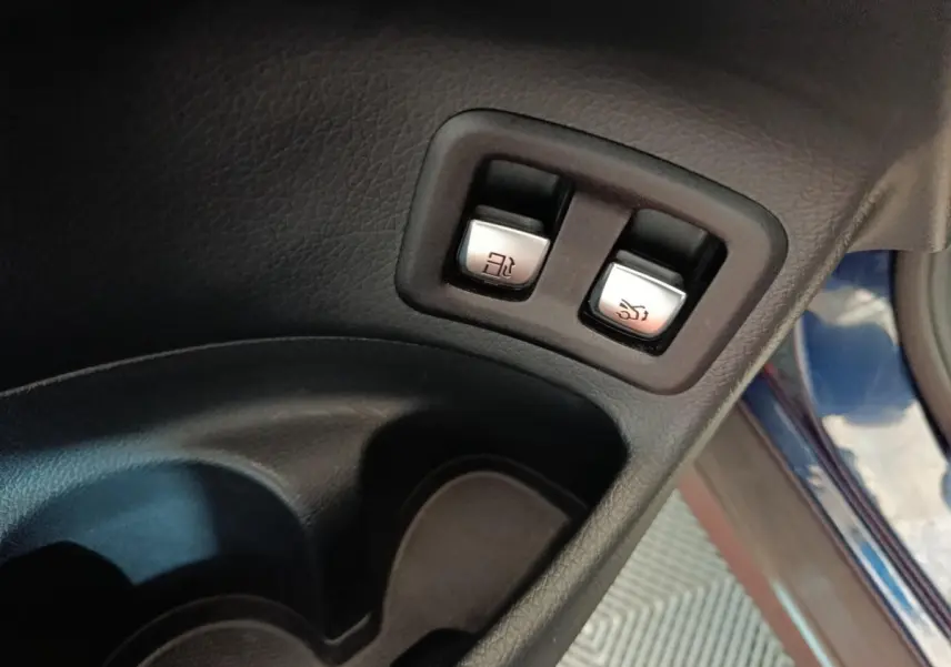 Boutons d'ouverture du coffre et de la trappe à carburant sur la porte côté conducteur d'un Mercedes GLC bleu 2021.