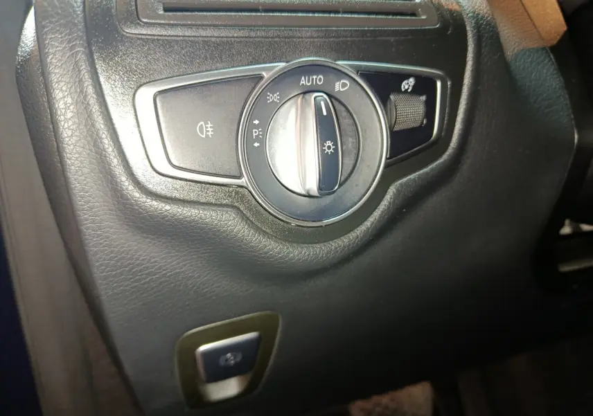 Gros plan sur le bouton de commande des phares dans l'habitacle noir du Mercedes GLC 300 E Business Line 2021.