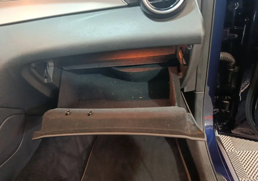Vue rapprochée de la boîte à gants ouverte côté passager d'un Mercedes GLC 300 E Business Line bleu 2021.