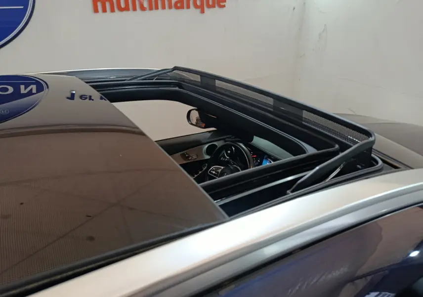 Vue rapprochée du toit ouvrant panoramique et intérieur noir du Mercedes GLC 300 E Business Line bleu.