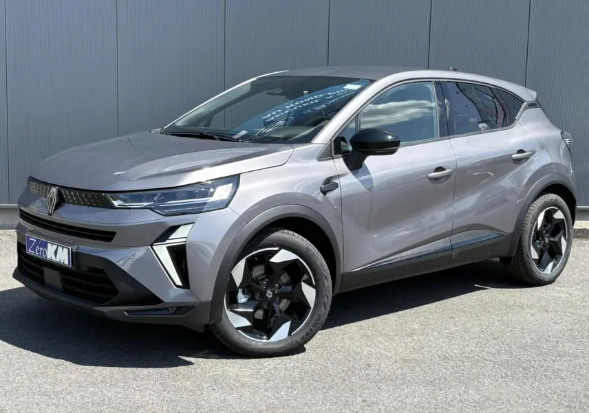 Renault Captur gris Cassiopée en 3/4 avant droit, avec jantes noires et phares LED distinctifs.