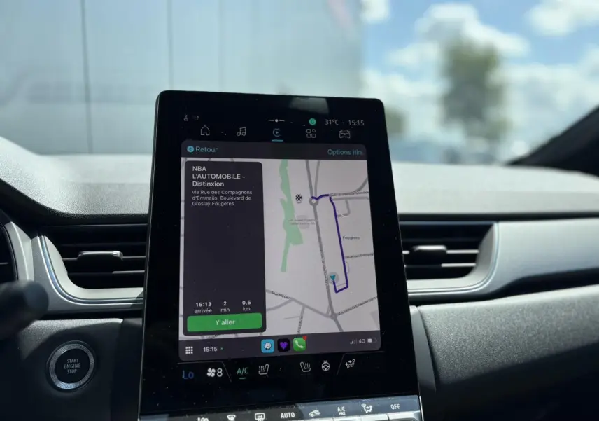Vue rapprochée de l'écran tactile central du Renault Captur gris Cassiopée affichant la navigation GPS et commandes climatisation.
