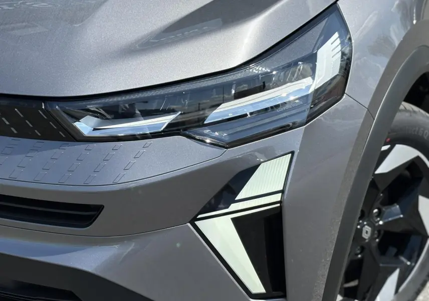 Gros plan sur l'avant droit du Renault Captur gris Cassiopée, mettant en valeur ses phares LED et jante aluminium 18 pouces.