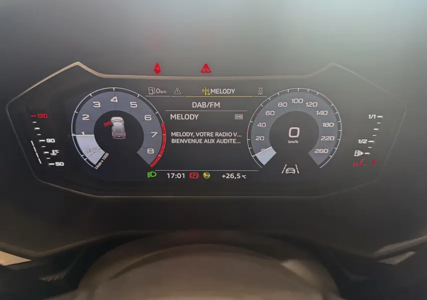 Tableau de bord numérique de l'Audi A1 2024 affichant la vitesse, régime moteur et radio DAB en veille.