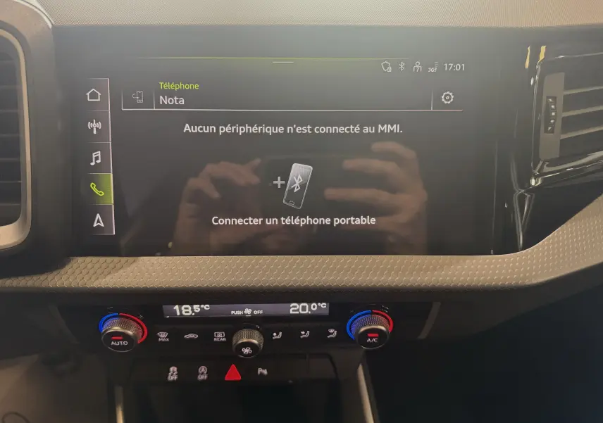 Vue rapprochée de l'écran tactile central et de la console de climatisation de l'Audi A1 2024 blanche toit noir.