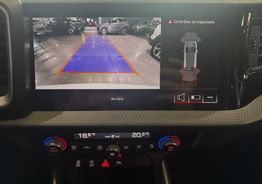 Écran multimédia de l'Audi A1 2024 affichant la caméra de recul avec guidage de trajectoire, tableau de bord noir.