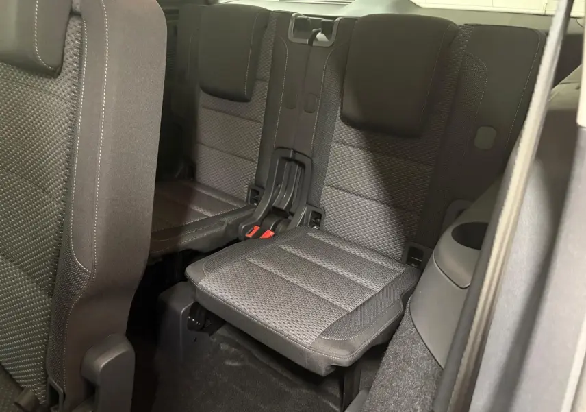 Vue intérieure sur la troisième rangée de sièges en tissu gris du Volkswagen Touran 2025, version 7 places.
