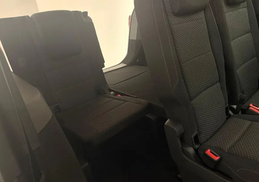 Vue intérieure sur la troisième rangée de sièges noirs en tissu du Volkswagen Touran 2025, version 7 places.