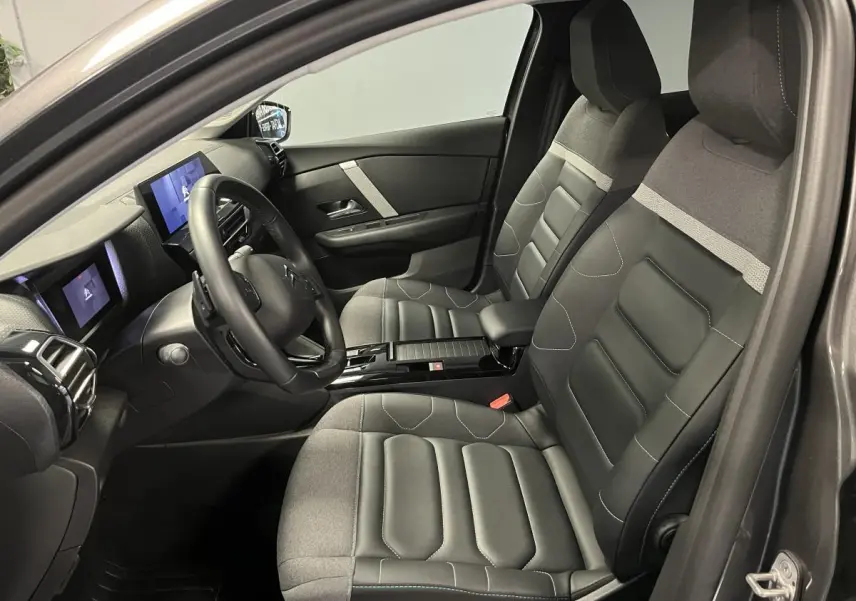 Intérieur avant de la Citroën C4 2024 gris, sièges Advanced Comfort en cuir et tissu, tableau de bord moderne avec écran tactile.
