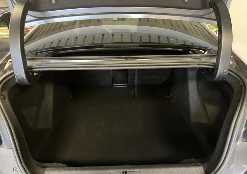Coffre ouvert d'une Citroën C4 2024 gris métallisé, vue arrière montrant l'espace de chargement vide.