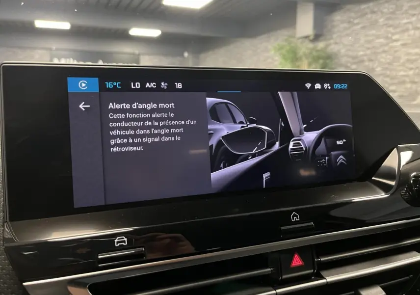 Écran tactile intérieur du Citroën C4 2024 montrant l'alerte d'angle mort avec vue sur rétroviseur côté gauche.