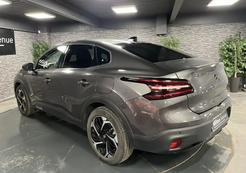 Vue 3/4 arrière droite d'une Citroën C4 gris métallisé avec feux arrière LED et jantes alliage 18 pouces.