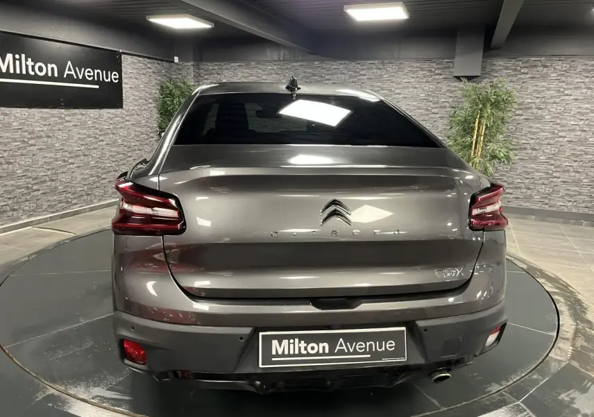 Vue arrière d'une Citroën C4 gris métallisé 2024 avec feux arrière LED et plaque Milton Avenue visible