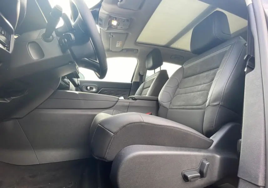 Intérieur noir du Citroën C5 Aircross Hybrid 145, vue côté conducteur avec sièges en cuir et toit panoramique.