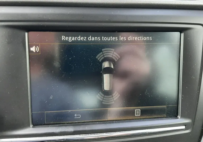 Écran central du tableau de bord du Renault Kadjar gris 2018 affichant l'alerte de surveillance des angles morts.