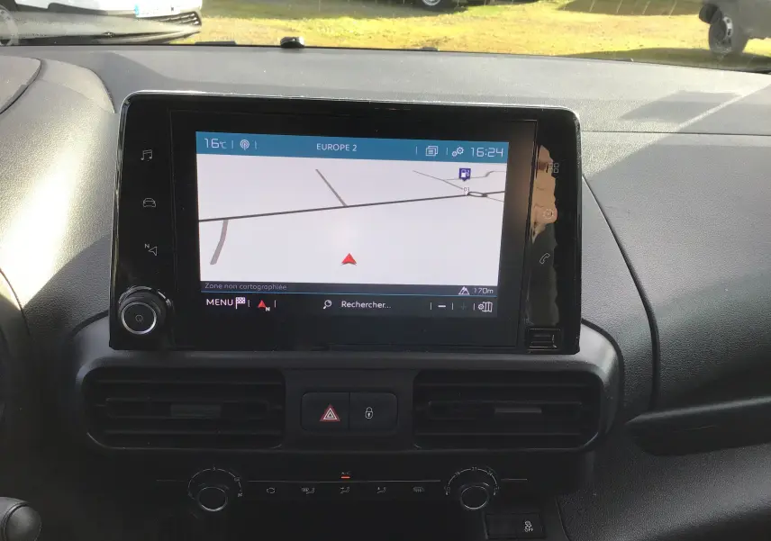 Vue rapprochée de l’écran tactile central du tableau de bord du Citroën Berlingo blanc, affichant un GPS.