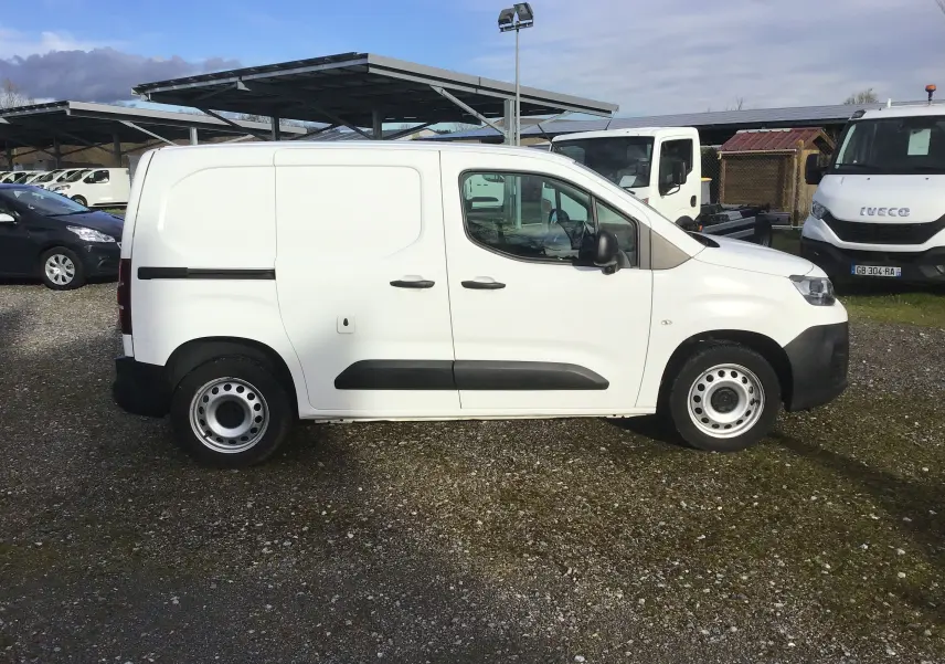 Vue de profil côté droit d’un utilitaire blanc Citroën Berlingo M 1.5 BlueHDi 2019 avec portes latérales et jantes acier.