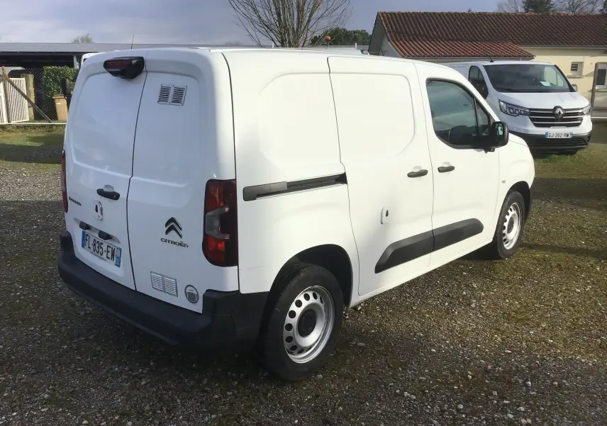 Vue 3/4 arrière droite d’un utilitaire Citroën Berlingo blanc de 2019 avec portes arrière battantes et protections latérales noires.