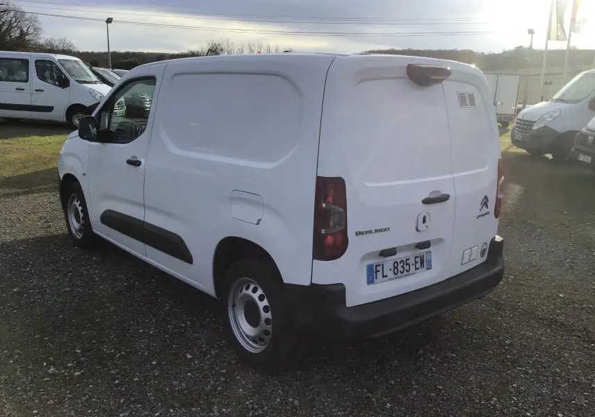 Vue 3/4 arrière droite d’un utilitaire Citroën Berlingo blanc, avec portes arrière fermées et plaque d’immatriculation visible.