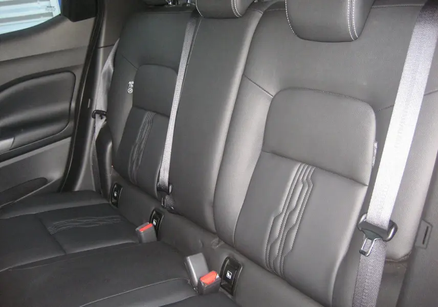 Vue intérieure montrant la banquette arrière en cuir noir avec ceinture grise du Nissan Juke 1.6 Hybrid 2024.